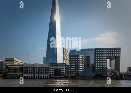 Sunlight reflects from the side of the 'Shard' skyscaper with the older London Bridge Hospital building in the foreground Stock Photo