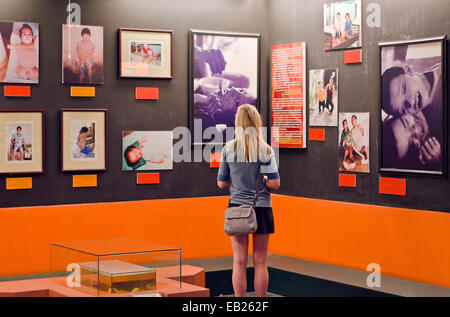 A tourist looking at the photos of agent orange victims at  War Remnants Museum, Ho chi minh, Vietnam Stock Photo
