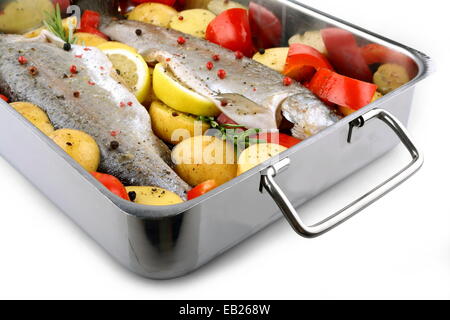 Two trout with potatoes and peppers on baking sheet, isolated Stock Photo