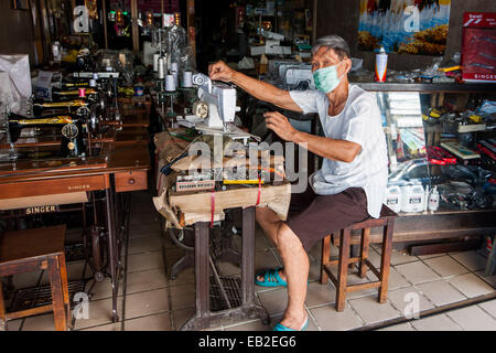Man using a sewing machine in a shop in Chiang Mai, Thailand Stock Photo