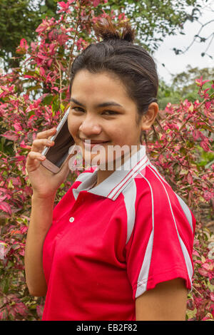 Closeup portrait friendly young smiling asian woman talks on telephone Stock Photo