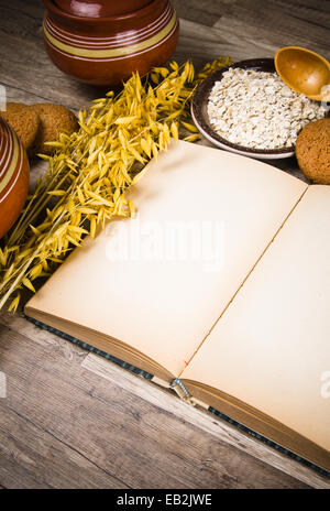 Oatmeal cookies and an old recipe book on the kitchen table Stock Photo