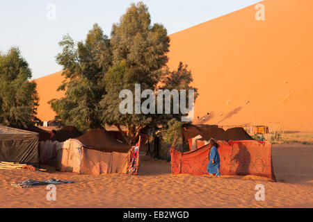 A Moroccan man walks among a tented camp located in the Sahara desert. Stock Photo