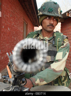 Srinagar, Kashmir. 25th November, 2014. An Indian secuirty police force (CRPF) stands guard out side polling station  the first phase of voting to the Jammu and Kashmir state assembly elections at  Bandipora , outskirts of Srinagar, Indian controlled Kashmir. Thousands lined up to cast their votes amid a boycott call by Muslim separatist groups who reject India's sovereignty over the disputed Himalayan region. Credit:  sofi suhail/Alamy Live News Stock Photo