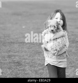 Girl carrying puppy dog Stock Photo