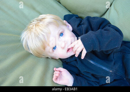 Overhead view of boy lying on garden chair