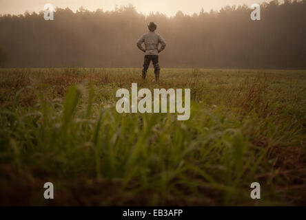 Mixed race man standing in field in rural landscape Stock Photo