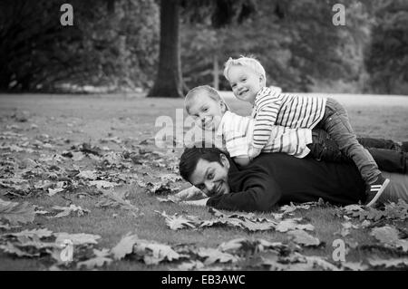 Portrait of father and sons lying on grass Stock Photo