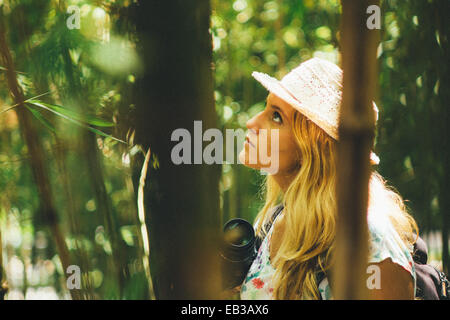 Woman standing in forest holding a camera, Fuengirola, Malaga, Spain Stock Photo
