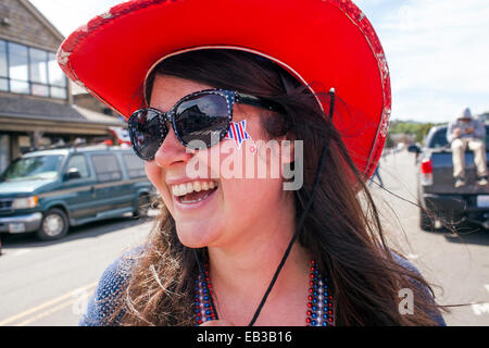 Caucasian woman wearing cowboy hat and face paint in street Stock Photo