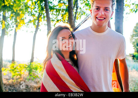 Caucasian couple wrapped in American flag Stock Photo