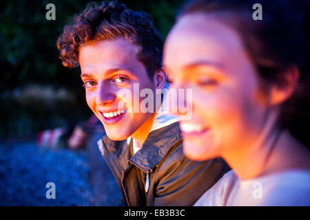 Caucasian couple relaxing together on beach at night Stock Photo