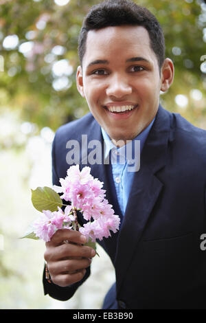 Smiling man in suit holding flower Stock Photo