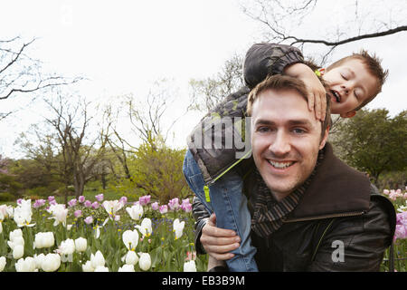 Father carrying son in park Stock Photo