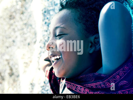 Girl lying on grass laughing Stock Photo