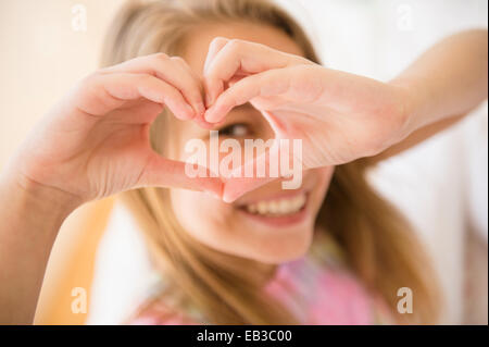 Caucasian girl making heart shape with hands Stock Photo