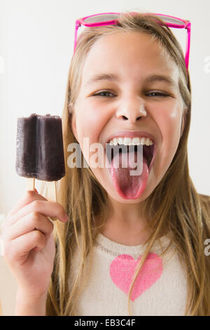 Caucasian girl with stained tongue from grape popsicle Stock Photo