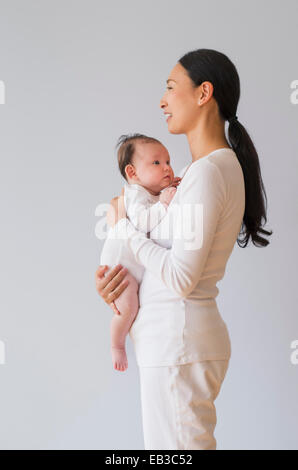 Profile of Asian mother holding baby Stock Photo