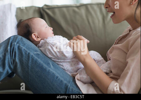 Asian mother playing with baby in living room Stock Photo