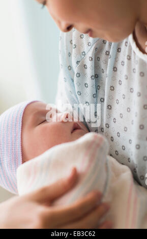 Asian mother holding newborn baby in hospital Stock Photo