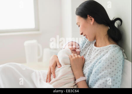 Asian mother holding newborn baby in hospital Stock Photo