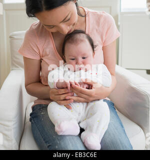 Asian mother playing with baby in living room Stock Photo