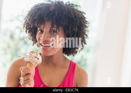 African American woman eating ice cream cone Stock Photo