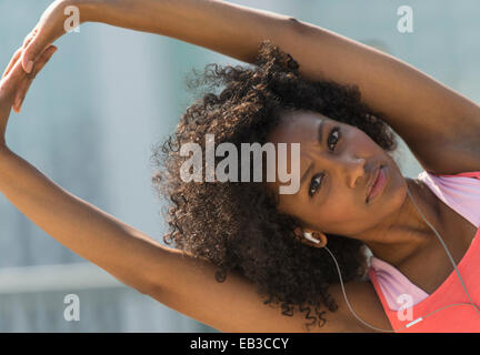 Mixed race woman stretching arms Stock Photo