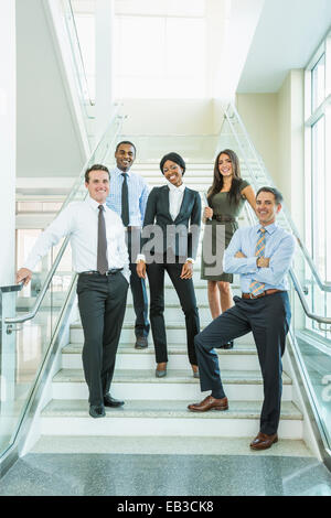Business people smiling on office staircase Stock Photo