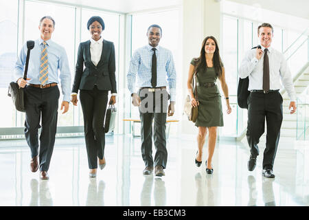 Business people walking in office lobby Stock Photo