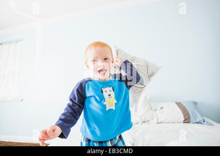 Caucasian boy having pillow fight in bedroom Stock Photo