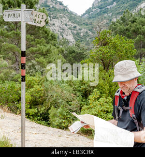 Spain, Catalonia, Tarragona, Priorat, Ulldemolins, Hiker on mountain trail looking at map near direction sign Stock Photo