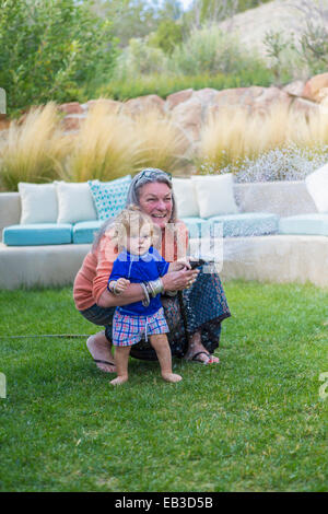 Caucasian grandmother hugging baby grandson in backyard Stock Photo