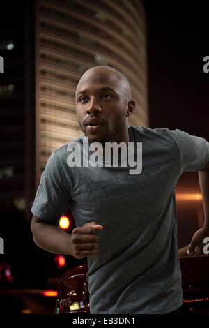 Black man running in city at night Stock Photo
