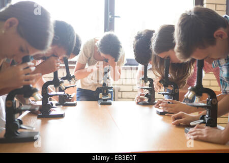 Students using microscopes in science class Stock Photo
