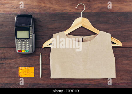 Shirt on hanger, credit card and machine on store counter Stock Photo