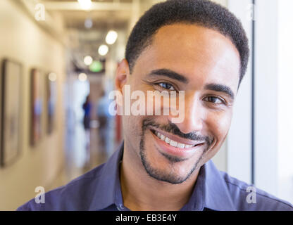 Black businessman smiling in office hallway Stock Photo