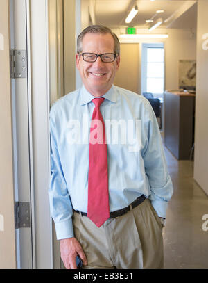 Caucasian businessman smiling in office hallway Stock Photo