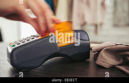 Woman swiping credit card through credit card reader Stock Photo