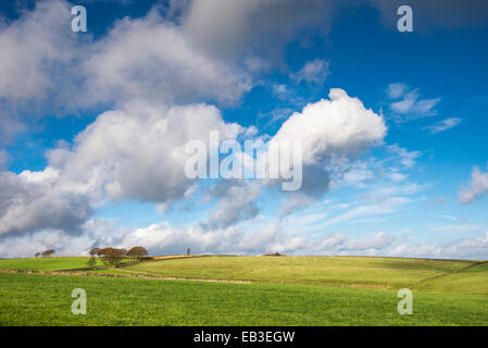 Big sky with fluffy clouds floating over green fields in a West Yorkshire landscape near Holmfirth.