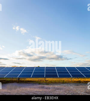 Solar panels under blue sky in remote landscape Stock Photo