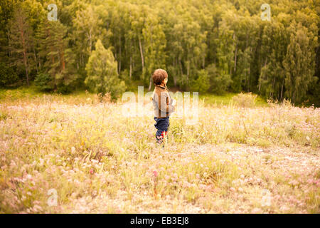 Mixed race boy standing in rural field Stock Photo