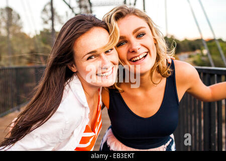 Caucasian teenage girls smiling on wooden bridge Stock Photo