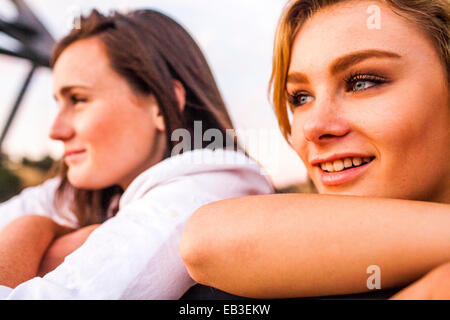 Caucasian teenage girls leaning on banister together Stock Photo