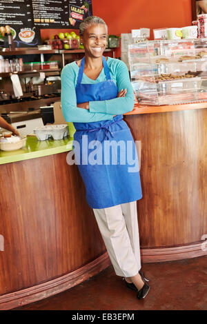 Black server smiling in cafe Stock Photo