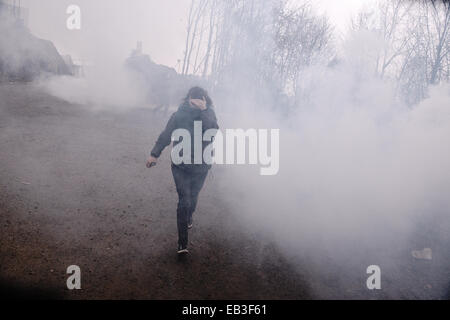 A demonstrator runs after a tear gas attack by the police during a demonstration against the operation of gold mines in Skouries, Chalkidiki, Greece