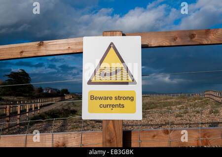 Beware strong currents warning sign by the beach Stock Photo