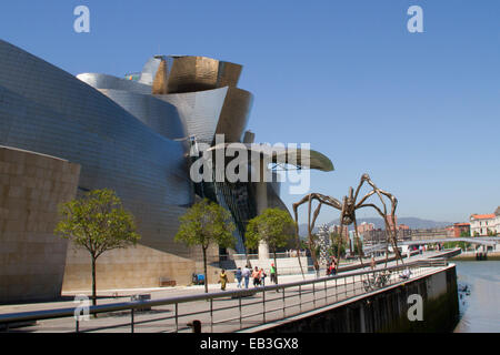 Bilbao Guggenheim Museum designed by Frank Ghery on the banks of the Nervion River with giant spider sculpture called Maman Bilb Stock Photo
