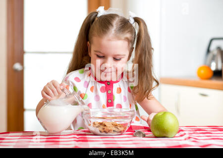 kid preparing corn flakes with milk Stock Photo