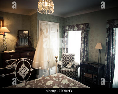 bridal suite, hotel room with wedding dress hanging and shoes on chair waiting for the bride, bridal preparations portmerion Stock Photo
